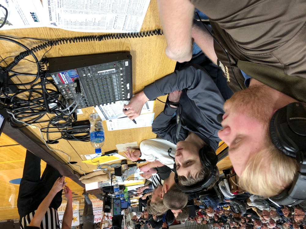 Students doing play-by-play court side at Mustang men's basketball